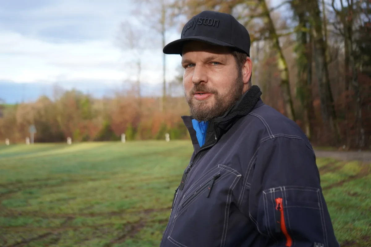 Roland Käser steht in der beschädigten Wiese.
